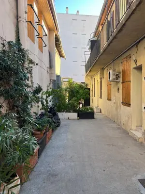an alley with potted plants on the side of a building at Apparemment151 in Cannes