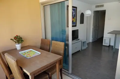 a dining room with a table and chairs at Le Beach 1 min plage , piscine , terrasse in Cannes
