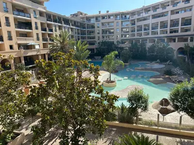 an apartment complex with a swimming pool in front of a building at Le Beach 1 min plage , piscine , terrasse in Cannes