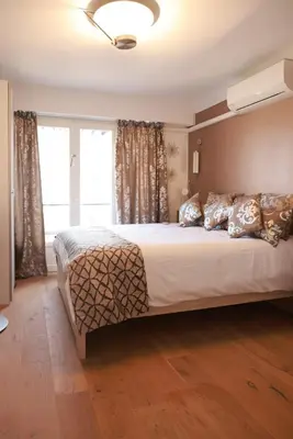a bedroom with a large bed and a window at Beautiful renovated luxury apartment terrace parking in Cannes