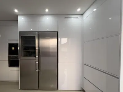 a stainless steel refrigerator in a kitchen with white cabinets at Beautiful renovated luxury apartment terrace parking in Cannes