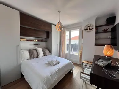 a bedroom with a bed and a desk and a window at Beautiful renovated luxury apartment terrace parking in Cannes