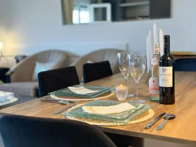a wooden table with a bottle of wine and a glass at Beautiful renovated luxury apartment terrace parking in Cannes