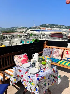 a table with plates on it on a balcony at Beautiful renovated luxury apartment terrace parking in Cannes