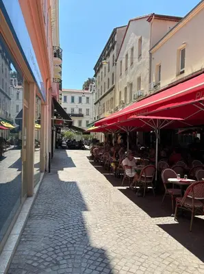 an empty street with tables and chairs and umbrellas at Cannes 1 bedroom apartment - FC8 in Cannes