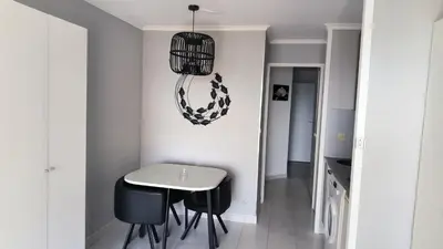 a dining room with a table and chairs and a chandelier at Palm d'Azur 459 in Cannes