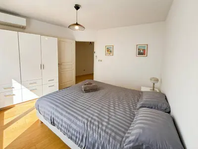 a bedroom with a bed with a blue comforter at CAM103 - Beau 2 pièces avec terrasse in Cannes