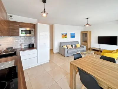 a kitchen and living room with a table and a couch at CAM103 - Beau 2 pièces avec terrasse in Cannes