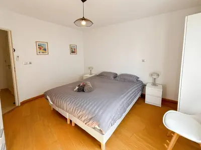 a bedroom with a bed with a dog laying on it at CAM103 - Beau 2 pièces avec terrasse in Cannes