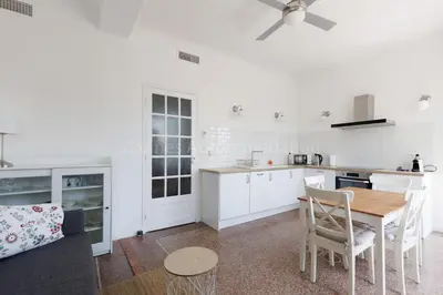a kitchen with white cabinets and a table and chairs at Soeur in Cannes