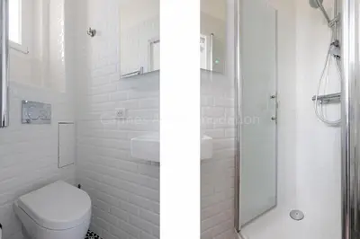 a white bathroom with a shower and a toilet at Soeur in Cannes