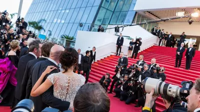 a group of people on a red carpet with a camera at Soeur in Cannes