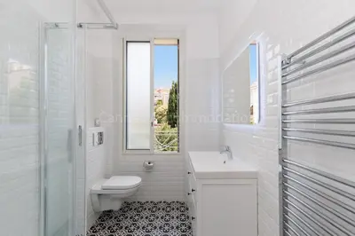 a white bathroom with a toilet and a sink at Soeur in Cannes