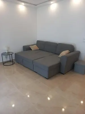 a blue couch in a living room with a tile floor at Cannes 5min plages in Cannes