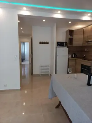 a living room with a table and a kitchen at Cannes 5min plages in Cannes