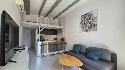 a living room with a couch and a kitchen at LX154 Loft rénové lumineux - plein centre Cannes in Cannes