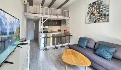 a living room with a couch and a table at LX154 Loft rénové lumineux - plein centre Cannes in Cannes
