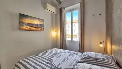 a bedroom with a bed with a picture on the wall at LX154 Loft rénové lumineux - plein centre Cannes in Cannes