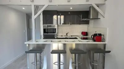 a kitchen with a counter with stools in it at LX154 Loft rénové lumineux - plein centre Cannes in Cannes