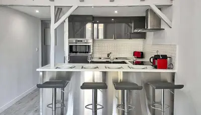 a kitchen with a counter with stools in it at LX154 Loft rénové lumineux - plein centre Cannes in Cannes