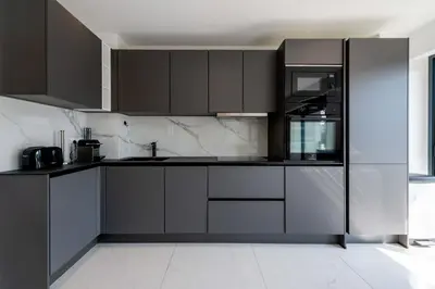 a kitchen with gray cabinets and a black refrigerator at Central 1-Br with Balcony Rue d’Antibes Cannes in Cannes