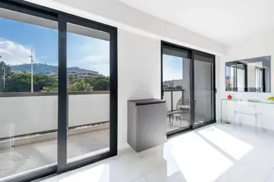 a room with glass windows and a kitchen with a view at Central 1-Br with Balcony Rue d’Antibes Cannes in Cannes
