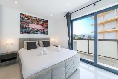 a bedroom with a large bed and a large window at Central 1-Br with Balcony Rue d’Antibes Cannes in Cannes