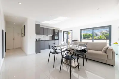 a kitchen and living room with a table and chairs at Central 1-Br with Balcony Rue d’Antibes Cannes in Cannes