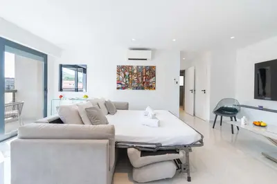 a white living room with a couch and a table at Central 1-Br with Balcony Rue d’Antibes Cannes in Cannes