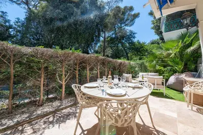 a patio with a table and chairs and trees at Ground-Floor Apartment with Private Garden Cannes in Cannes