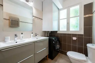 a bathroom with a sink and a washing machine at Ground-Floor Apartment with Private Garden Cannes in Cannes