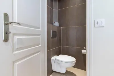 a bathroom with a toilet and a white door at Le 45 Clémenceau - Superbe logement proche plages et Palais in Cannes