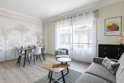 a living room with a couch and a table at Le 45 Clémenceau - Superbe logement proche plages et Palais in Cannes