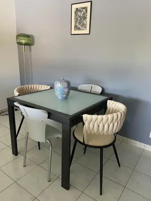 a black table with two chairs and a vase on it at Prince de Galles in Cannes
