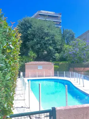 a swimming pool with a fence around it at Prince de Galles in Cannes