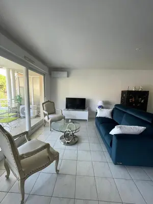 a living room with a blue couch and chairs at Prince de Galles in Cannes