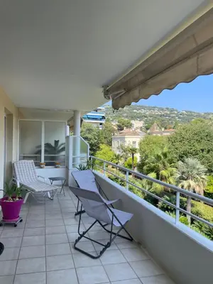 a balcony with chairs and a view of the city at Prince de Galles in Cannes