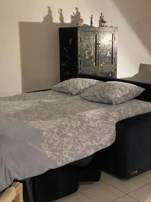 a bed with a blue comforter and two pillows at Prince de Galles in Cannes