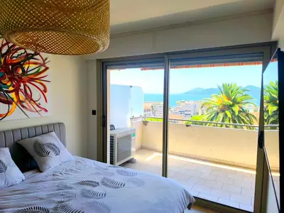 a bedroom with a bed and a view of the ocean at 3-room air-conditioned terrace, sea view in Cannes