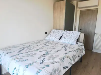 a bedroom with a bed with a blue and white comforter at 3-room air-conditioned terrace, sea view in Cannes