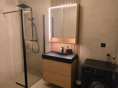 a bathroom with a sink and a shower and a washing machine at 3-room air-conditioned terrace, sea view in Cannes