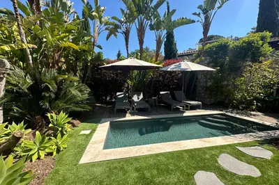 a swimming pool in a yard with chairs and umbrellas at Cannes - Villa for rent - 2179 in Cannes