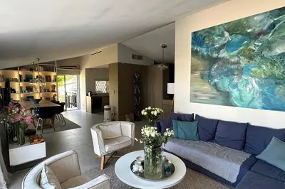 a living room with a blue couch and a painting at Cannes - Villa for rent - 2179 in Cannes
