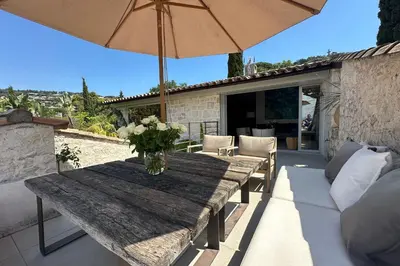 a wooden table with a vase of flowers and an umbrella at Cannes - Villa for rent - 2179 in Cannes
