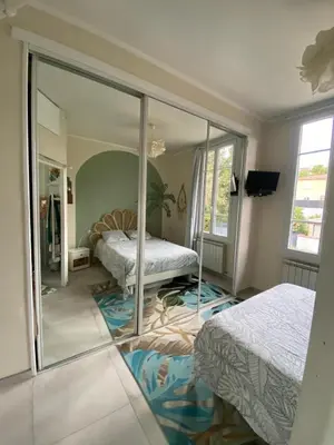 a bedroom with two beds and a mirror at Villa piscine cannes 2 chambres in Cannes