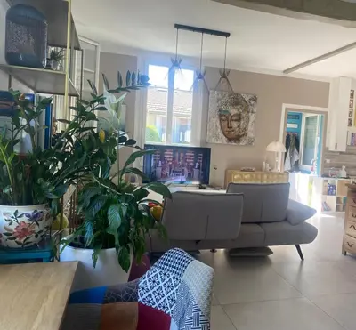 a living room with a couch and some plants at Villa piscine cannes 2 chambres in Cannes