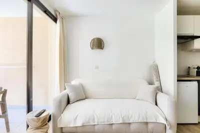 a white couch sitting in a living room at Résidence Cannes Villa Francia - maeva Home - Appartement climatisé 2 pièces 4 personnes - Prestige - super Home MAE-1343 in Cannes