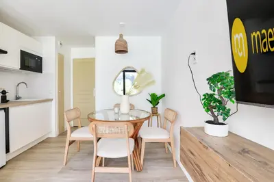 a kitchen and dining room with a glass table and chairs at Résidence Cannes Villa Francia - maeva Home - Appartement climatisé 2 pièces 4 personnes - Prestige - super Home MAE-1343 in Cannes
