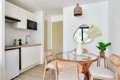 a kitchen and dining room with a glass table and chairs at Résidence Cannes Villa Francia - maeva Home - Appartement climatisé 2 pièces 4 personnes - Prestige - super Home MAE-1343 in Cannes