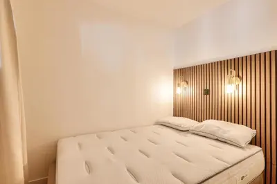 a bedroom with a bed with a wooden headboard at Résidence Cannes Villa Francia - maeva Home - Appartement climatisé 2 pièces 4 personnes - Prestige - super Home MAE-1343 in Cannes